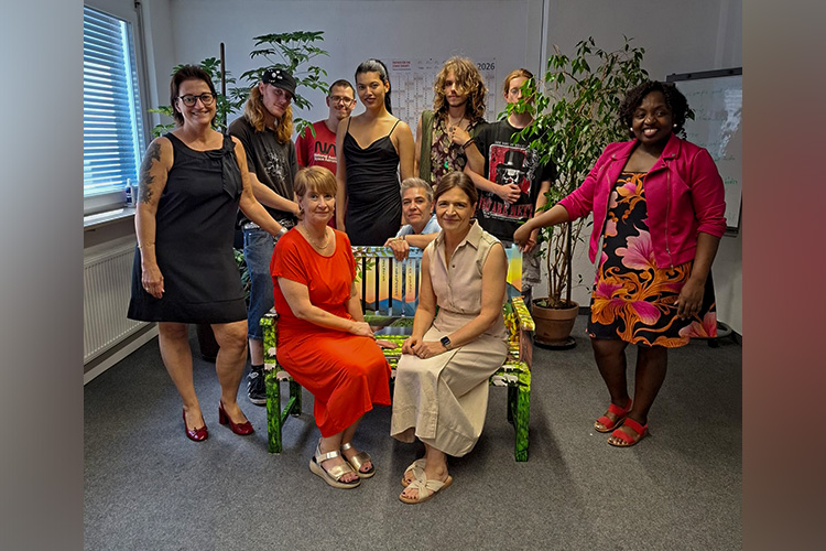 Die Teilnehmenden des MIA-Projekts übergeben gemeinsam mit Daniela Zimmermann (Leitung bfz DUA, stehend links) ihre kreativ gestaltete Motivationsbank an Christine Wible (stellvertretende Geschäftsführerin, rechts auf Bank sitzend) und Katrin Eberhardt (Teamleiterin U25). Hinter der Bank kniend Kathrin Dudziak, Coach der Maßnahme MIA, und rechts neben der Bank Charleine Yewou, Coach der Maßnahme MIA.