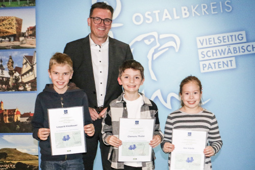 Die Siegerin und die Sieger des Luftballon-Weitflug-Wettbewerbs (v. l.) Leopold Kleebauer, Clemens Thaler und Josi Hänle (1. Platz) zusammen mit Landrat Dr. Joachim Bläse