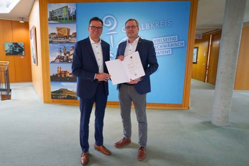 Landrat Dr. Joachim Bläse (links) überreicht Bürgermeister Markus Knoblauch die Ehrenurkunde des Ostalbkreises für 25-jährige Zugehörigkeit zum Öffentlichen Dienst.