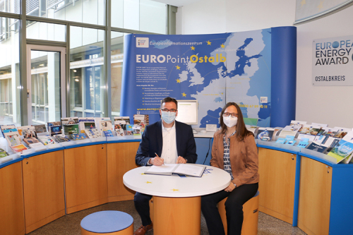 Landrat Dr. Joachim Bläse und die Leiterin des EUROPE DIRECT EUROPoint Ostalb, Andrea Hahn, bei der Unterzeichnung der Partnerschaftsvereinbarung mit der EU-Kommission