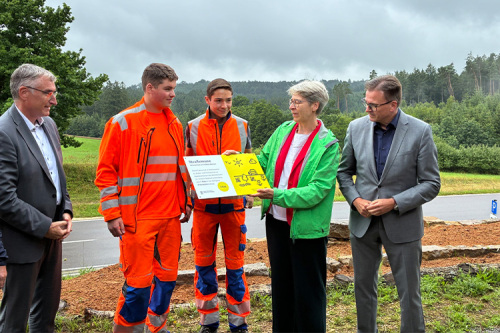 Staatssekretärin Elke Zimmer (2. v. r.) übergibt die Tafel „Straßenoasen“ an die Auszubildenden der Straßenmeisterei Ellwangen im Beisein von Landrat Dr. Joachim Bläse (rechts) und Dezernent Karl Kurz (links).